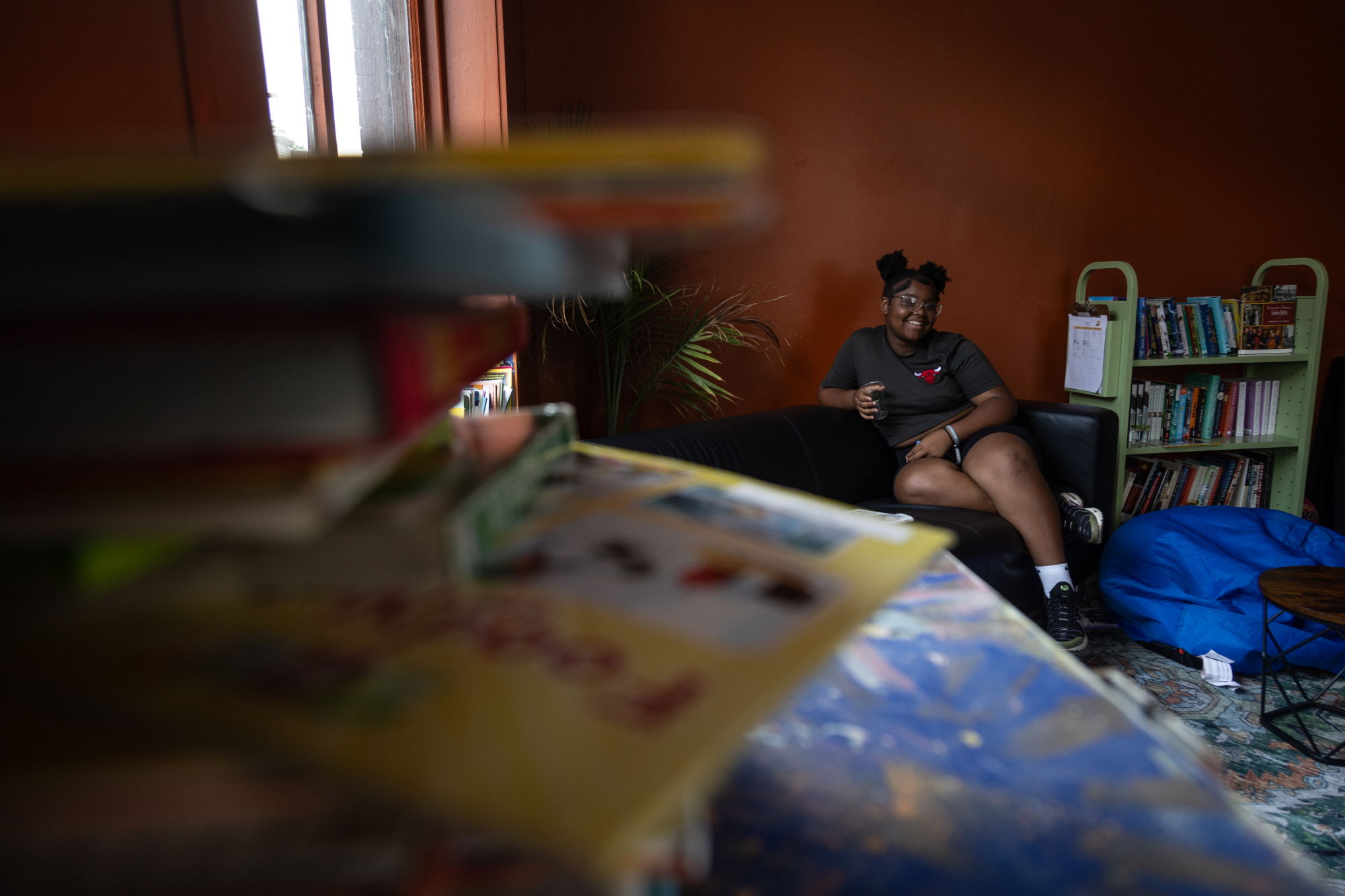 Da'Veh sits on the couch at the Simple Way Library