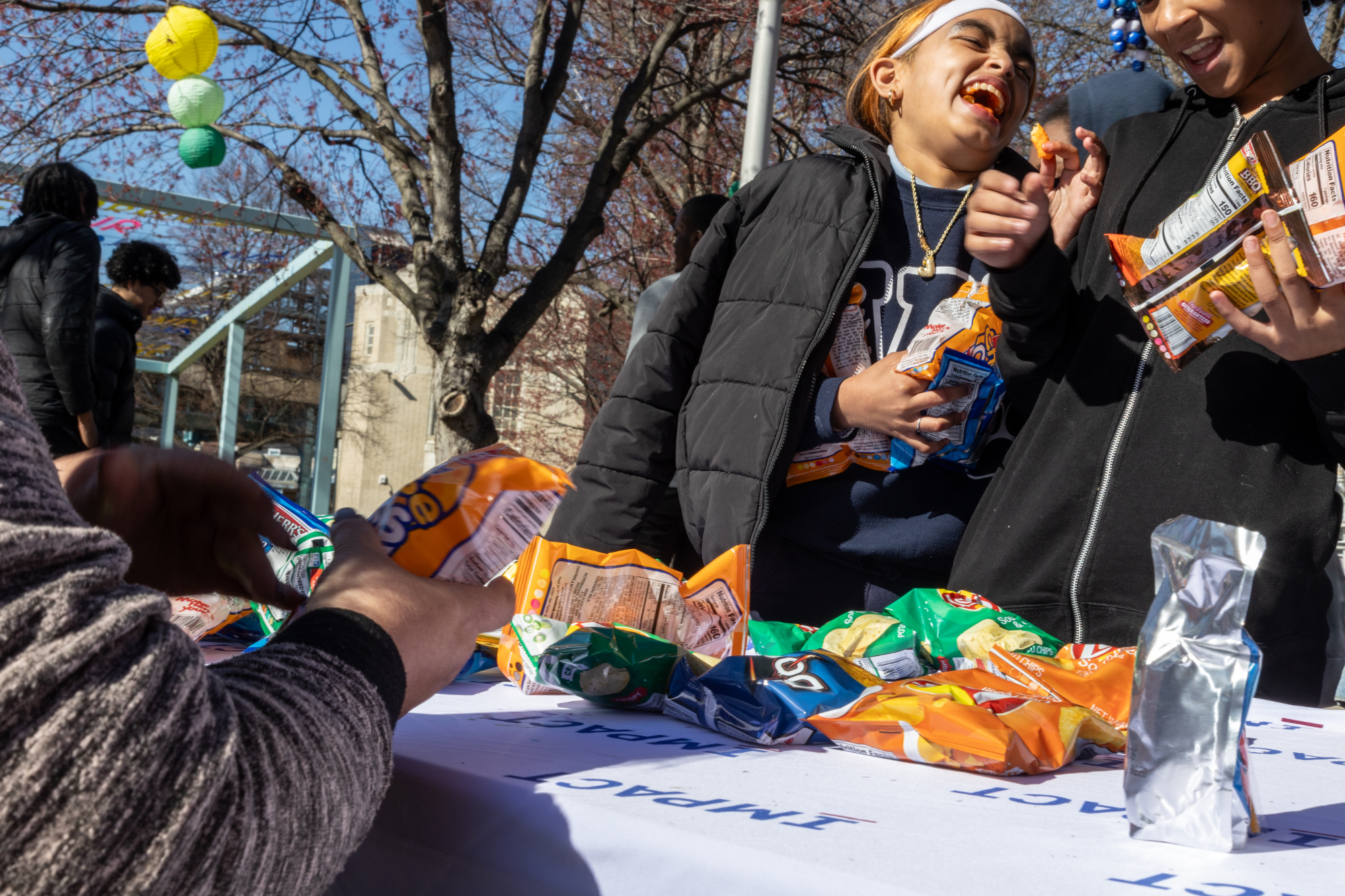Teen laughs while grabbing snacks at IMPACT Services Spring event