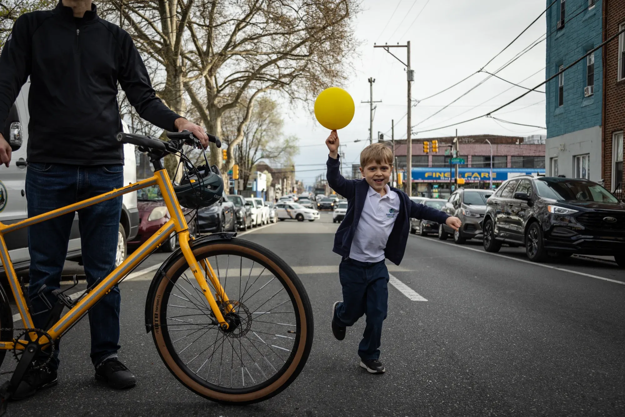 Boy runs with yellow balloon on closed street