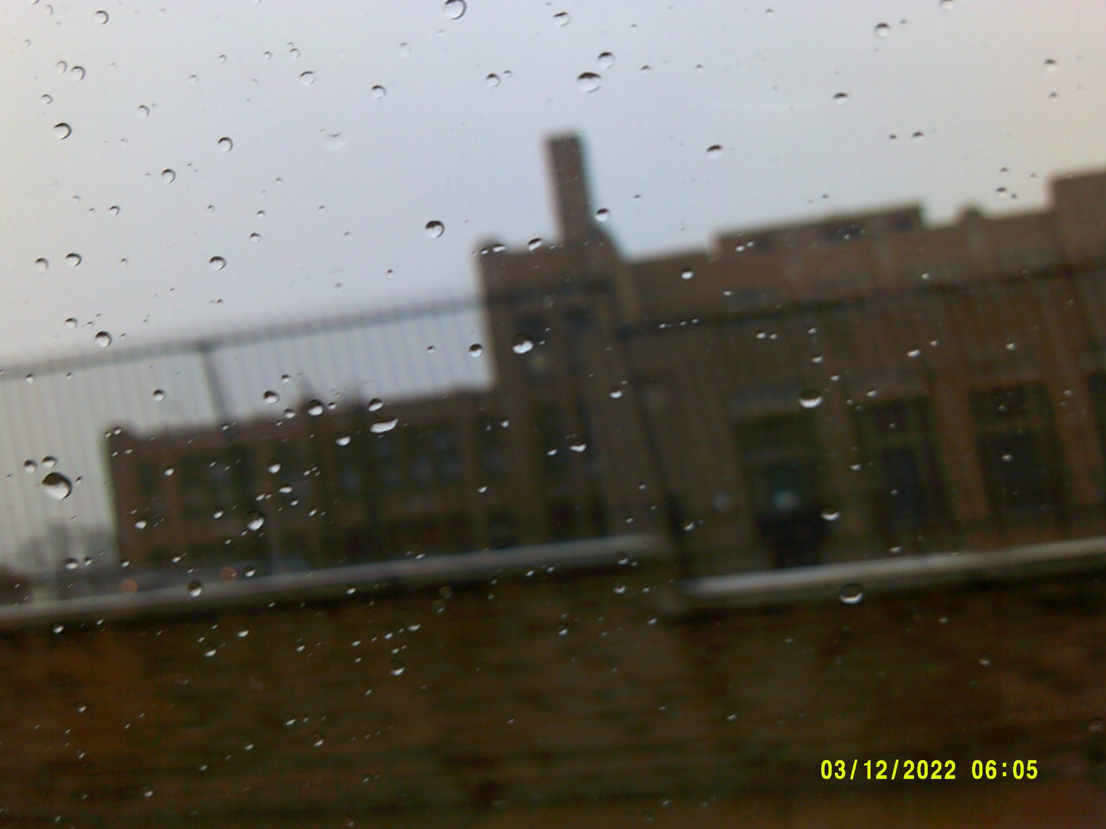 Elkin student Nyla snaps a photo of a nearby building on a rainy day for her Photovoice project.
